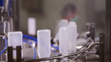 Sos üretim hattı. Yarı şeffaf plastik şişeler üretim hattından geçiyor. Sosu işlemek için otomatik çizgi