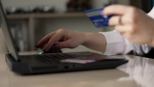 若い女性の手は クレジットカードでオンラインで購入しています 女性はラップトップを使用して自宅でオンライン取引を行っています — ストック動画