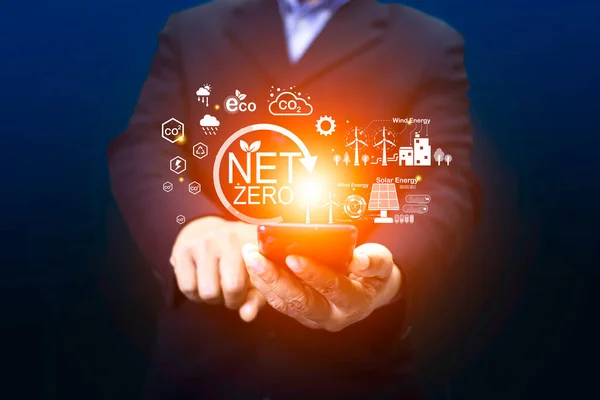 net zero concept Hand holding net zero icon on blurred smart phone. It is surrounded by a clean energy icon.Carbon gas affects global warming. Concept with innovation inspiration. Idea from big data