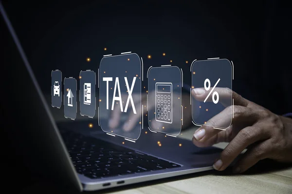 Businessman using laptop to fill in the income tax online return form for payment.business using computer filling personal income tax return to pay tax.Futuristic virtual screen interface technology