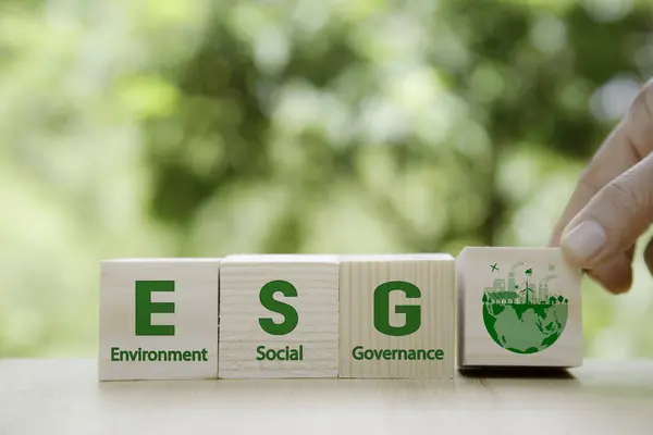 ESG icon in wood on green background. Investing in environmental, social, governance or Invest ESG in industry. ESG investment. Green renewable energy concept. Innovation technology ecology energy.