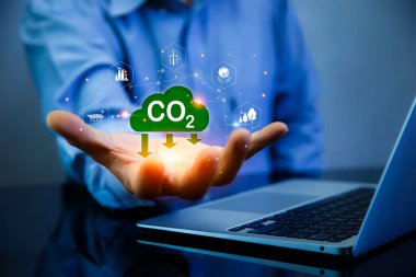 Yeşil enerji, karbon emisyonlarının azaltılması, karbon nötr konsept. Elinde karbon azaltma işareti var. 2050 yılında net sıfır sera gazı emisyonu hedefi. Endüstride karbondioksit salınımı.