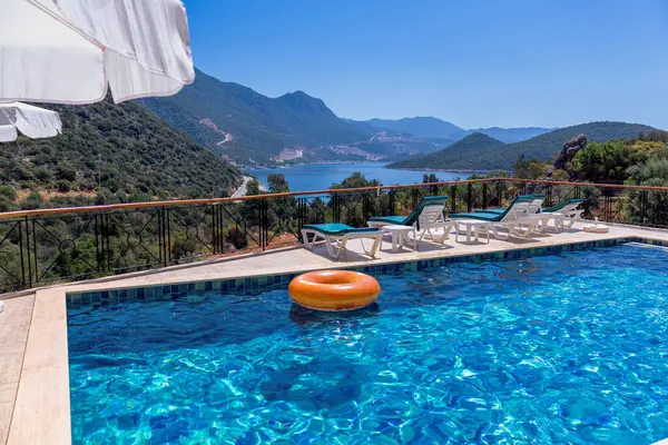 Turuncu şişme daireli yüzme havuzu. Arka planda deniz ve dağlar.