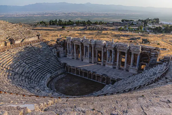 Yazın günbatımında Panorama antik Greko Roma şehrinde insanlar olmadan. Pamukkale 'deki antik amfitiyatronun kalıntıları, Hierapolis, Türkiye. Harap olmuş antik şehir.