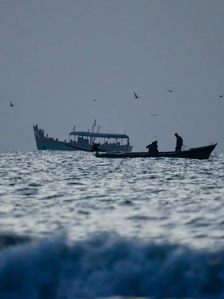 stock image silhouette of boat in the sea, early morning fishing in the sea