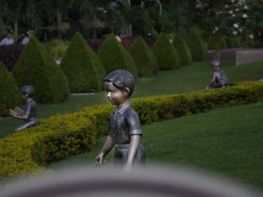 Bazı aktiviteleri temsil eden parktaki bir çocuğun heykeline odaklan.