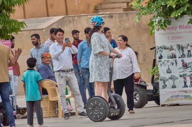 Jaipur, Hindistan; 06-28-2023: Bir bayan halka açık bir yerde uçan kaykaya biniyor