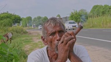 Rajasthan, Hindistan; 08-21-2023: Yaşlı bir Hintli adam 'ÇOCLAM' olarak adlandırılan geleneksel bir Hint şeyi içiyor