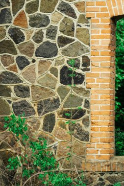 Yeşil çimenli eski bir binanın taş duvarı