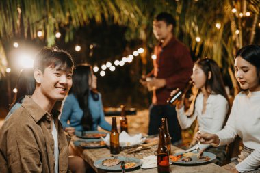 Gülümseyen genç adam bahçede eğleniyor.