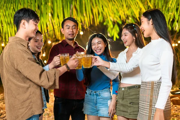 Group of friends standing and toasting beers at a party