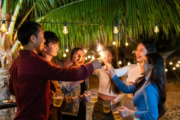 Asian young party people happily hold sparkles in celebration