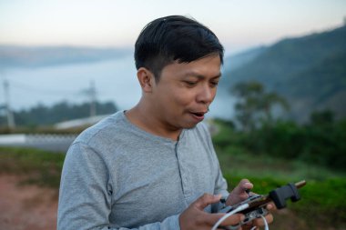 Genç Asyalı içerik yaratıcısı seyahat ederken İHA pilotu