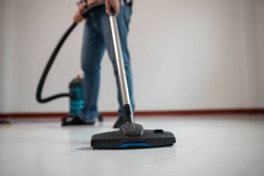 Minimalist Odasında Modern Elektrikli Süpürge ile Yerleri Süpüren Kişi