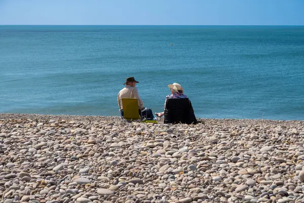 stock image Couple sitting on the beach at Budleigh Salterton, Devon, United Kingdom