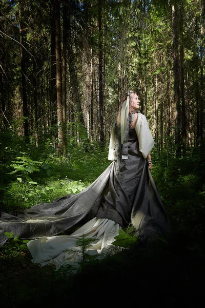 Beautiful seductive dryad. Pagan spirit of forest. Portrait of beautiful dryad. Fairy who loves nature in beautiful green summer forest. Concept of environmental friendliness and caring for nature