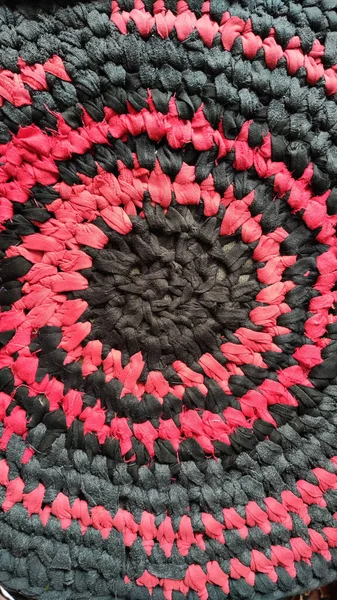 Knitted black and red texture and background. Rurfl rustic traditional round rug