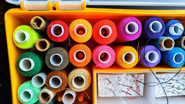 Storage box with spools of multi-colored threads, sewing needles. Storage system for sewing needlework at home and office