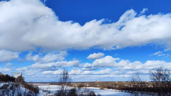 Beautiful landscape with sky, clouds and river with ice on a sunny spring day
