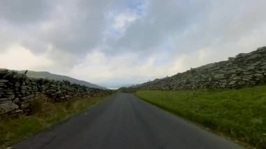 4K video, Lake District, Cumbria, İngiltere kırsalında dar bir şerit boyunca sürüyor.