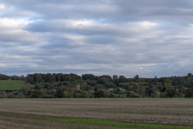 A view across the rural landscape with the village of Woolsthorpe in the distance in Lincolnshire, UK clipart