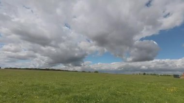 İngiltere 'nin Suffolk kırsalındaki bir tarladan geçen bulutların 4k zamanlaması