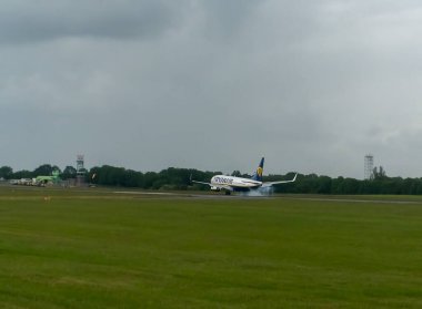 Bir Ryanair uçağı Essex, İngiltere 'deki Stansted Havaalanına inerken lastiklerden dumanlar yükseliyor.