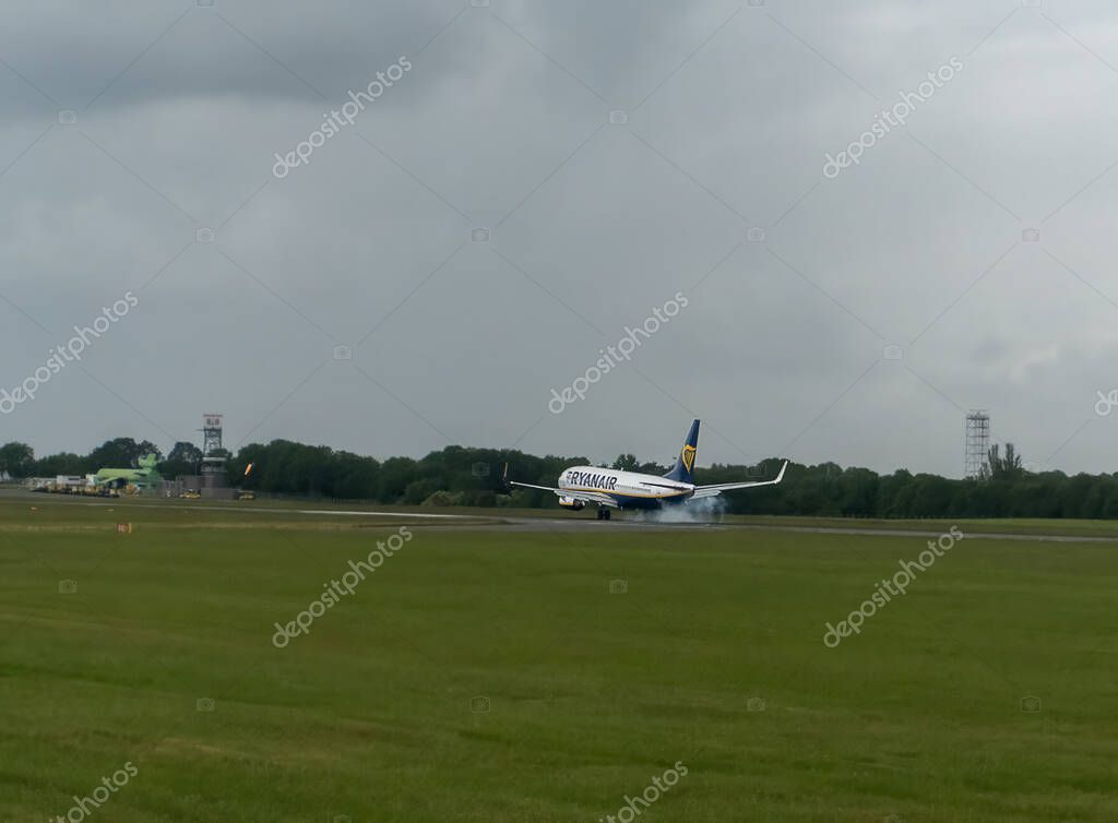 Smoke from the tyres as a Ryanair flight touches down at Stansted Airport in Essex, UK