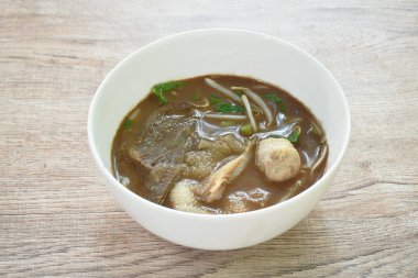 Kaynamış biftek ve siyah bitki çorbasında köfte.