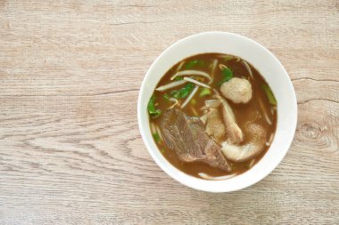 Kaynamış biftek ve siyah bitki çorbasında köfte.