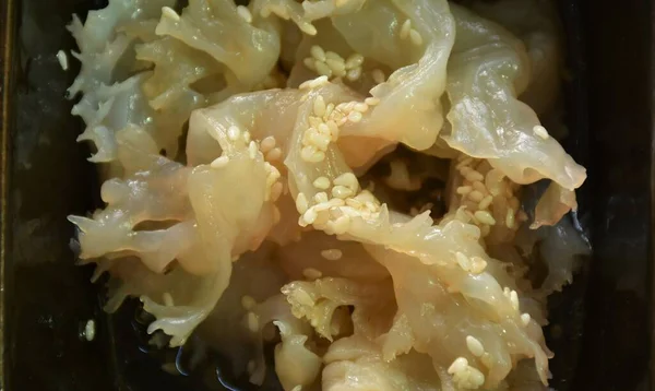 fermenting jellyfish in white sesame oil on bowl