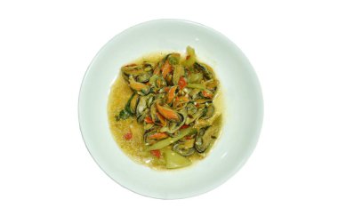 Baharatlı kızarmış midye dilimlenmiş soğan ve tabakta fesleğen yaprağı.