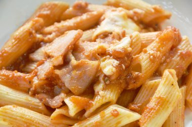 Domuz sucuğu soslu makarna ketçaplı kızarmış pirzola ve tabakta peynir sosu.   