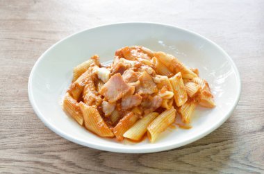 Domuz sucuğu soslu makarna ketçaplı kızarmış pirzola ve tabakta peynir sosu.   