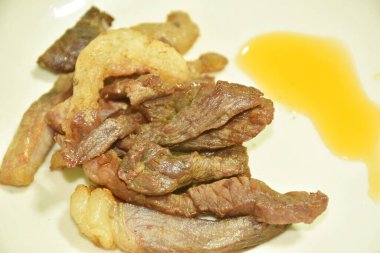 Kızarmış tuzlu biftek ve tabakta soslu sos. 