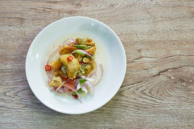 Kızarmış yılan derisi gourami baharatlı ve ekşi Tayland salatası. 
