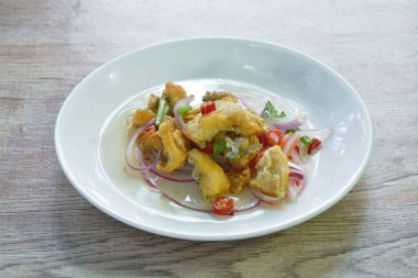 Kızarmış yılan derisi gourami baharatlı ve ekşi Tayland salatası. 