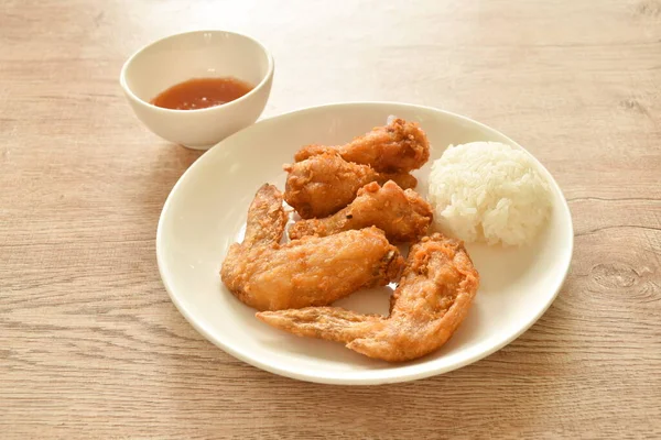 crispy fried chicken drumstick and wing dipping chili sauce eat with sticky rice on plate