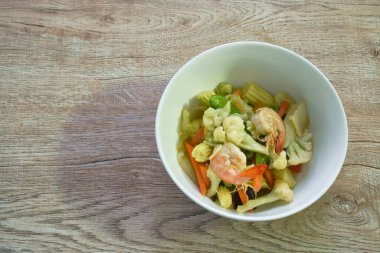 Kızarmış karnabahar ve karidesle karışık sebzeleri karıştırın.   