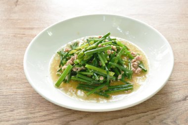 Kızarmış sarımsaklı soğan ve domuz pirzolası karıştırın.