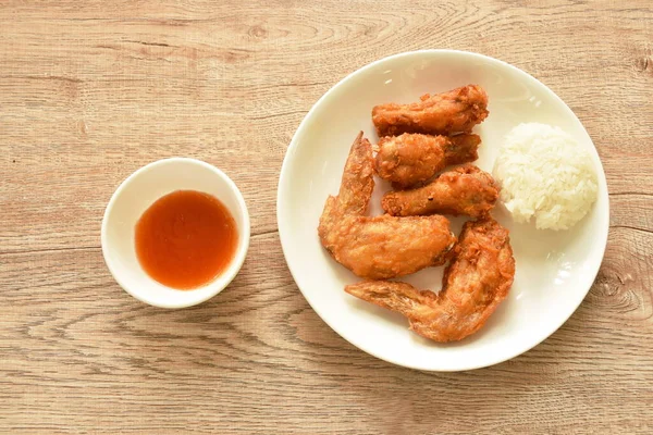 crispy fried chicken drumstick and wing dipping chili sauce eat with sticky rice on plate