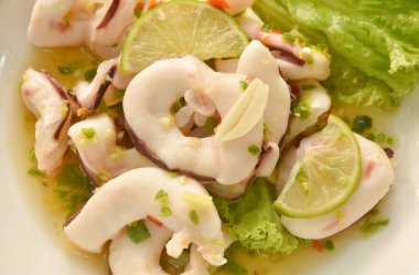 Thai spicy and sour steamed slice squid with lemon salad on plate  