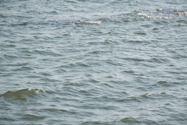 Günbatımı arka planında ve dokusunda su yüzeyinde dalga 