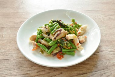 spicy fried slice yard long bean chili squid with basil leaf on plate