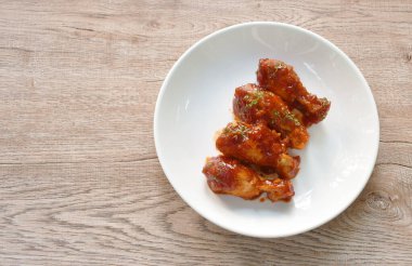 crispy fried chicken drum wing dressing tomato sauce and topping oregano on plate