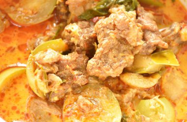 spicy boiled beef meat with eggplant in coconut milk green curry soup on bowl 