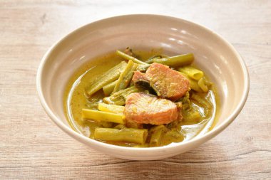 boiled dry salty mackerel fish with morning glory and pineapple in curry soup on bowl
