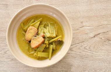 boiled dry salty mackerel fish with morning glory and pineapple in curry soup on bowl