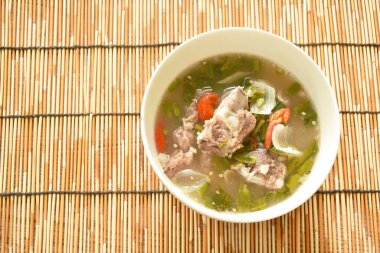 sıcak ve baharatlı domuz kemik demirhindi ve Tay otlar çorba kase üzerinde 