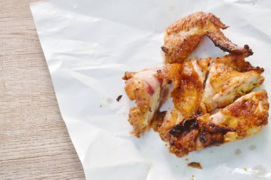 Beyaz kâğıt ambalajında ızgara tavuk kanadı.